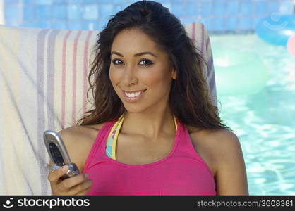 Portrait of woman with mobile phone at swimming pool