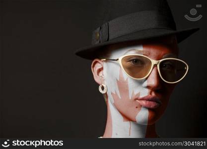 Portrait of woman with painted Canada flag and sunglasses. Portrait of woman with painted Canada flag and sunglasses on black background