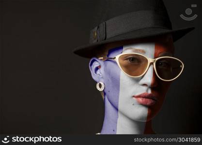 Portrait of woman with painted France flag and sunglasses. Portrait of woman with painted France flag and sunglasses on black background