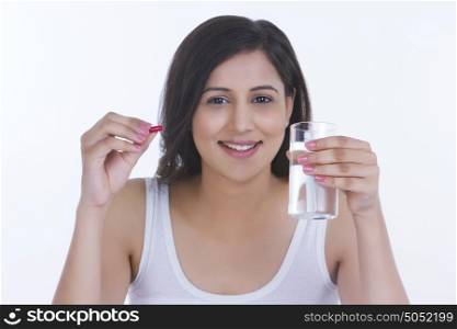 Portrait of woman with pill and glass of water