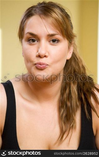 Portrait of woman with pursed lips and playful expression