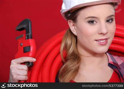 Portrait of woman with wrench and pipe