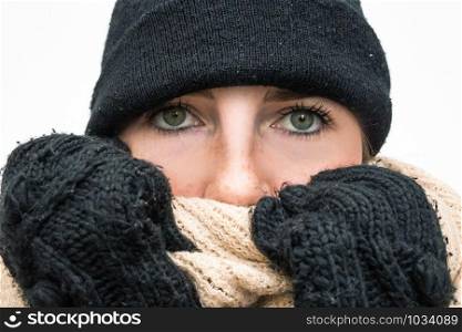 Portrait of woman wrapped in winter had and scarf, winter woolen wearing looking cold closeup. Portrait of woman wrapped in winter had and scarf, winter woolen wearing looking cold