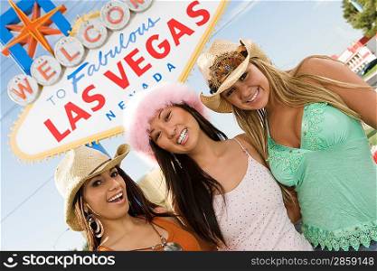 Portrait of women in front of Las Vegas welcome sign, Nevada, USA