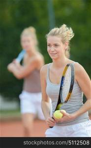 portrait of women playing tennis doubles