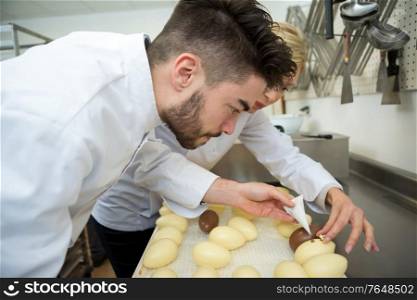 portrait of worker checking chocolate eggs