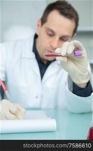 portrait of worker holding a blood test