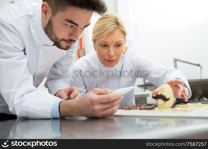 portrait of workers and chocolate eggs