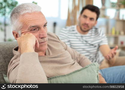 portrait of worried senior man and his son