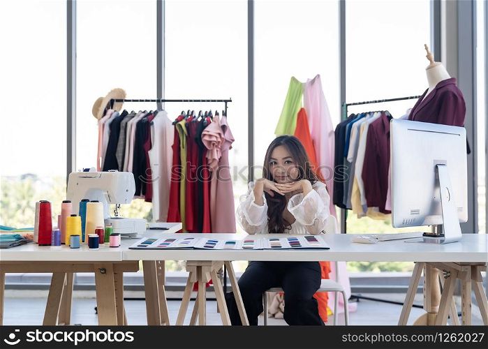 Portrait of young adult fashion designer as owner entrepreneur at her atelier studio. Using for entrepreneur startup concept.