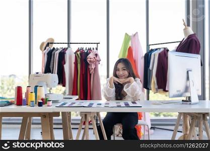 Portrait of young adult fashion designer as owner entrepreneur at her atelier studio. Using for entrepreneur startup concept.