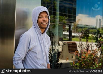 Portrait of young African American man in hooded sweatshirt outdoor.