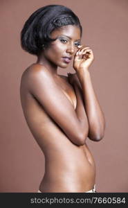 Portrait of young african american woman posing naked in studio