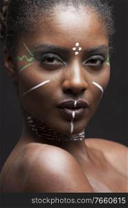 Portrait of young african american woman with traditional white paint on face 