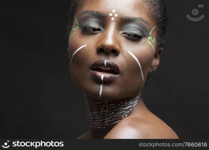 Portrait of young african american woman with traditional white paint on face 