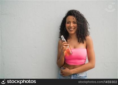 Portrait of young Afro american latin woman enjoying and drinking a bottle of beer. Lifestyle concept.