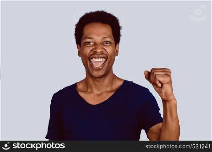 Portrait of young Afro American man celebration victory on studio.