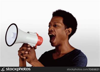 Portrait of young afro american man screaming on a megaphone. Marketing or sales concept.