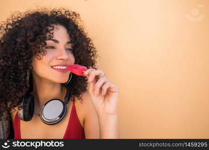 Portrait of young afro american woman enjoying summertime and eating an ice-cream. Lifestyle concept.