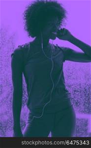 portrait of young afro american woman in gym while listening mus. portrait of young afro american woman in gym on workout break while listening music on earphone and dancing rainy day and bad weather outdooor duo tone filter