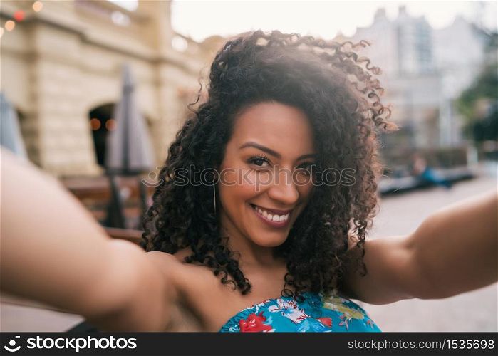 Portrait of young afro american woman taking a selfie outdoors in the street. Enjoying life. Lifestyle concept.