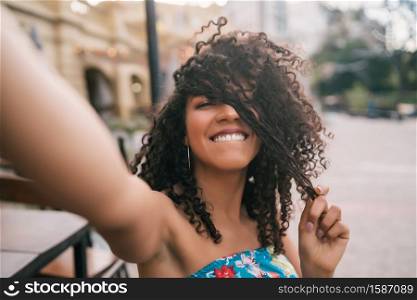 Portrait of young afro american woman taking a selfie outdoors in the street. Enjoying life. Lifestyle concept.