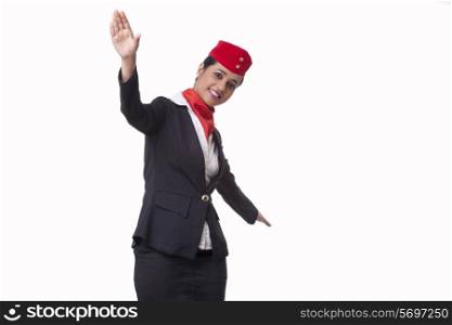 Portrait of young air hostess with arms outstretched isolated over white background
