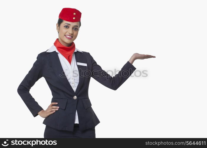 Portrait of young airhostess holding invisible product isolated over white background