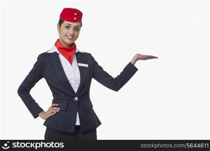Portrait of young airhostess holding invisible product isolated over white background