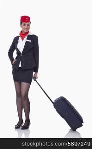 Portrait of young airhostess with luggage bag isolated over white background