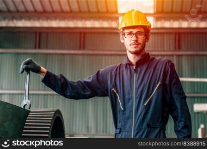 Portrait of young American happy worker enjoy happy smiling to work in a heavy industrial factory.to fix machine with big wrench.
