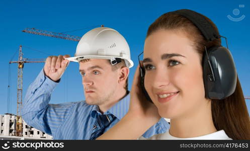 Portrait of young architects at in front of construction site, building and crane.