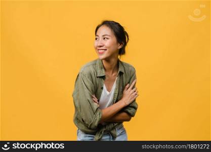 Portrait of young Asia lady with positive expression, arm crossed, smile broadly, dressed in casual cloth over yellow background. Happy adorable glad woman rejoices success. Facial expression concept.