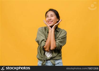 Portrait of young Asia lady with positive expression, smile broadly, dressed in casual clothing over yellow background. Happy adorable glad woman rejoices success. Facial expression concept.