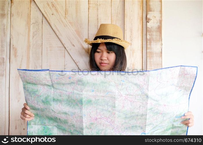 Portrait of young asian girl traveler holding map with smiling face, travel summer holiday vacation concept