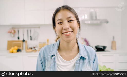 Portrait of young Asian Latin woman feeling happy smiling at home. Hispanic girl relax toothy smile looking to camera in kitchen at home in the morning concept.