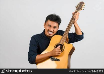 Portrait of Young Asian man playing an acoustic guitar isolated on white background. Music, entertainment and hobby concept.