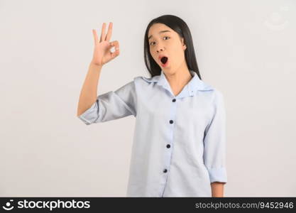 Portrait of young asian woman doing ok sign with hand and fingers over isolated white background. Advertising and lifestyle concept.