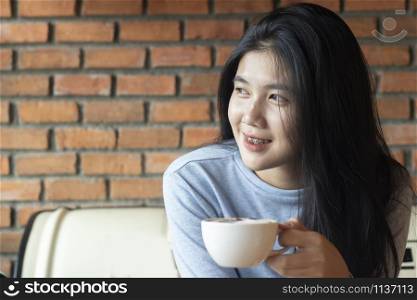 Portrait of young asian woman drinking coffee in coffee shop