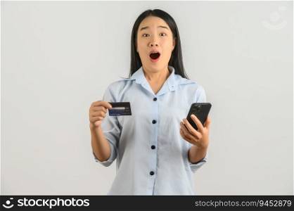 Portrait of Young asian woman expressing surprise while using mobile phone and holding credit card isolated over white background. Technology and payment online concept.