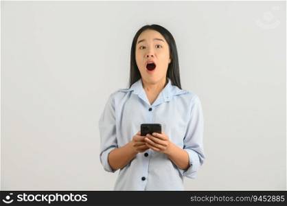 Portrait of Young asian woman expressing surprise while using mobile phone isolated over white background. Technology concept.