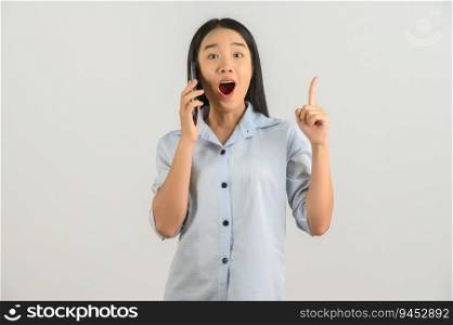 Portrait of Young asian woman expressing surprise while using mobile phone isolated over white background. Technology concept.