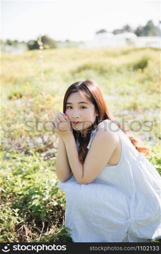 Portrait of Young Asian woman girl sitting and smile in flower garden