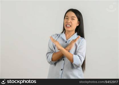 Portrait of Young asian woman in blue shirt crossed hands show no stop forbidden symbol isolated on white background. Expression and lifestyle concept.