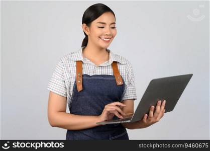 Portrait of young asian woman in waitress uniform holding a laptop computer posture, copy space to insert products for advertisement isolated on white background