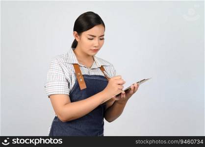 Portrait of young asian woman in waitress uniform holding clipboard and pen for checking order, copy space to insert products for advertisement isolated on white background