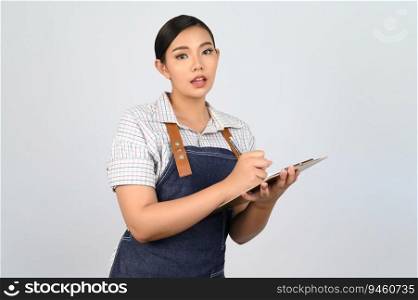 Portrait of young asian woman in waitress uniform holding clipboard and pen for checking order,©space to insert∏ucts for advertisement isolated on white background