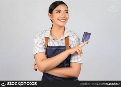 Portrait of young asian woman in waitress uniform pose with credit card in hand, copy space to insert products for advertisement isolated on white background