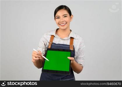 Portrait of young asian woman in waitress uniform use digital pen point on mock up tablet posture, copy space on green screen to insert products for advertisement isolated on white background