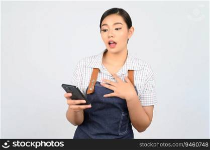 Portrait of young asian woman in waitress uniform use smartphone with feel surprise, copy space for insert products for advertisement isolated on white background